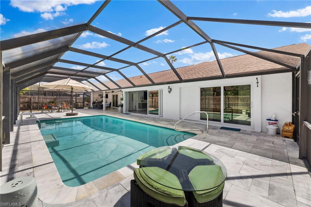 2467 Pinewoods Circle, Unit 3 Naples, FL 34105 - Photo 19 of 33 View of pool featuring a patio and glass enclosure