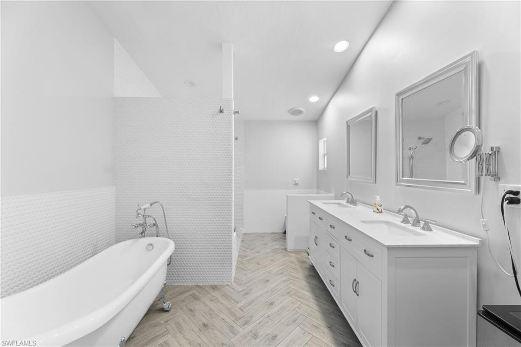 2467 Pinewoods Circle, Unit 3 Naples, FL 34105 - Photo 29 of 33 Bathroom featuring tile walls, vanity, parquet flooring, and independent shower and bath