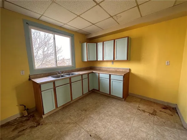 an empty room with windows and cabinet