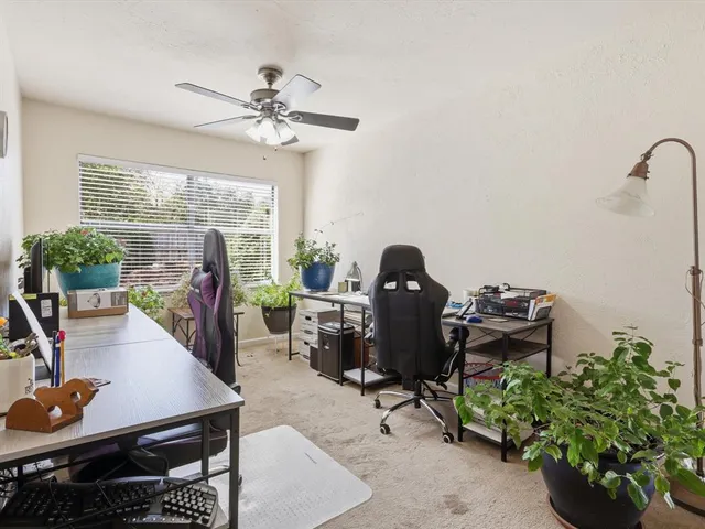 a view of a workspace with furniture and a window