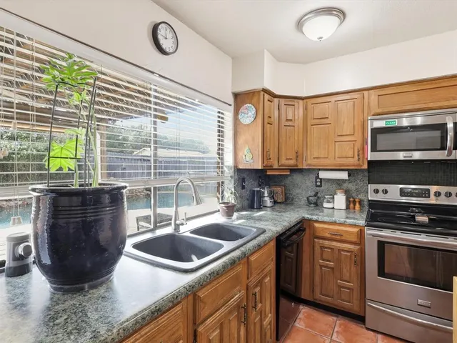 a kitchen with a sink a stove and cabinets