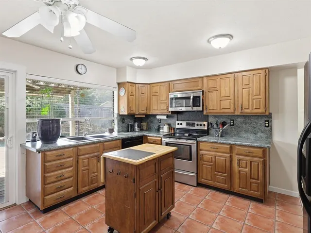 a kitchen with a sink stove top oven and microwave