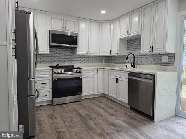 a kitchen with a stove a sink and a microwave