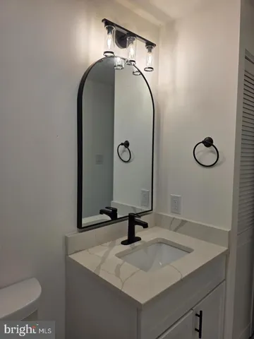 a bathroom with a sink and mirror with toilet