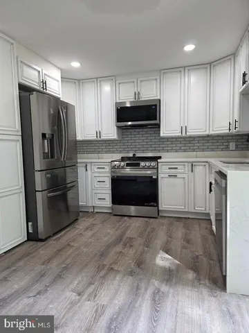 a kitchen with granite countertop a refrigerator stove and sink