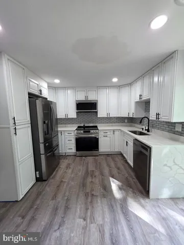 a large kitchen with a stove a refrigerator and a sink