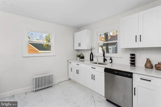 a kitchen with stainless steel appliances a refrigerator a stove a microwave and a window