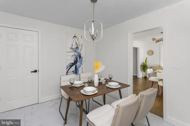 a dining room with wooden floor a chandelier a wooden table and chairs