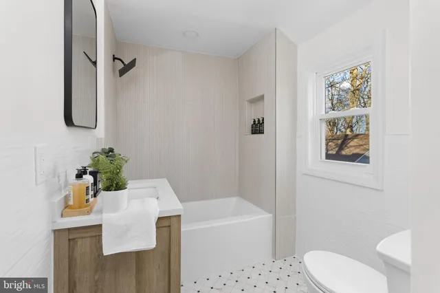 a bathroom with a bathtub sink and mirror