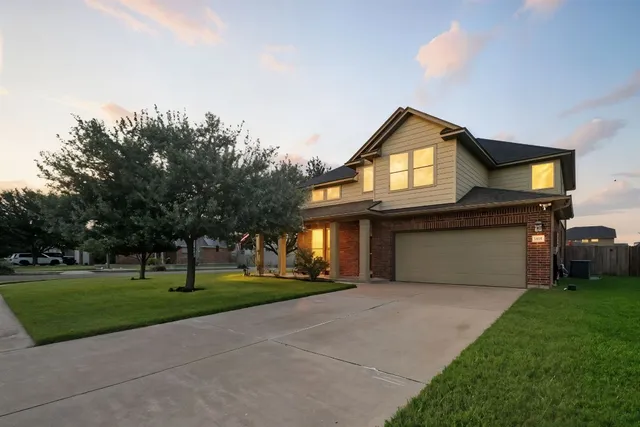 a front view of a house with a yard and trees