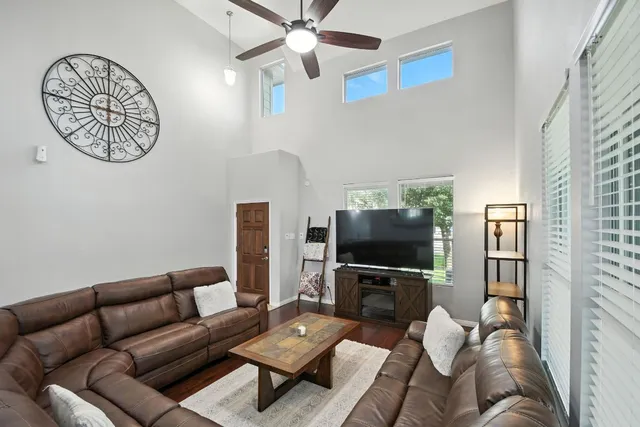 a living room with furniture a flat screen tv and a window