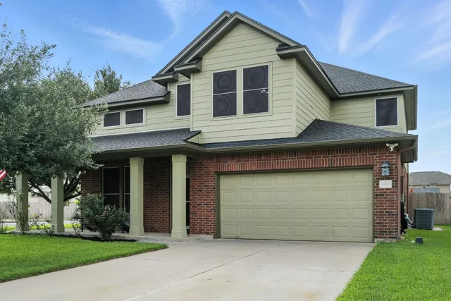 a front view of a house with a garden and garage