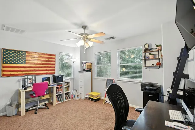 a view of a livingroom with workspace and a window