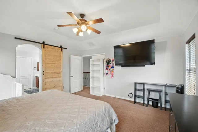 a bedroom with a bed and a flat screen tv