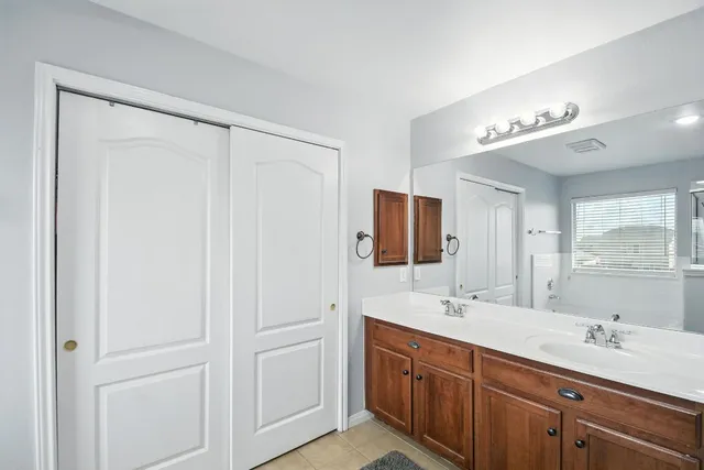 a bathroom with double vanity and a mirror