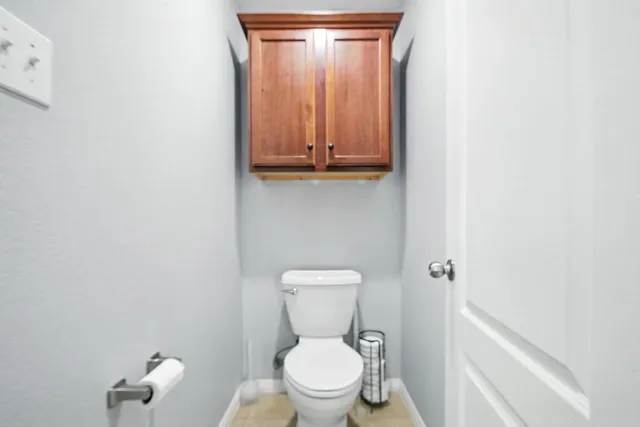 a white toilet sitting next to a shower