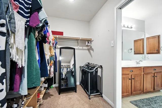 a view of walk in closet with clothes