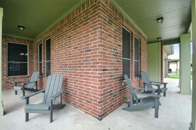 a balcony with chairs and a potted plant