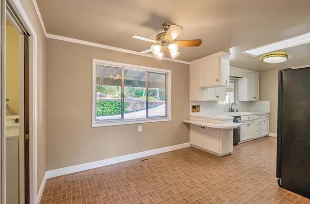 a living room with stainless steel appliances kitchen island furniture and a window
