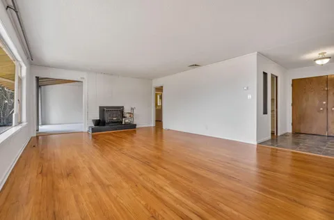 a view of empty room with wooden floor