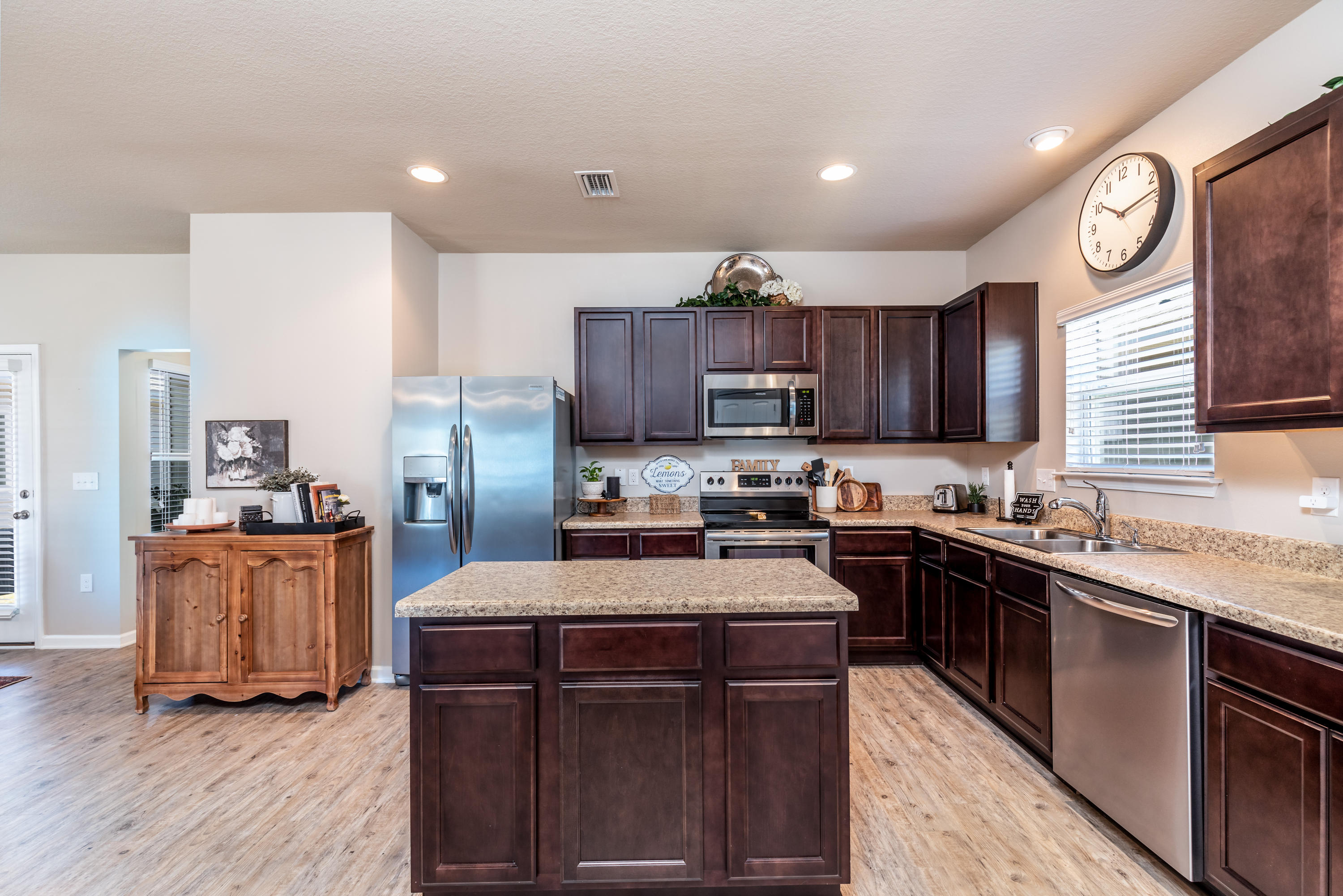 321 Fanny Ann Way Freeport, FL 32439 - Photo 7 of 38 a kitchen with stainless steel appliances granite countertop a stove top oven a sink dishwasher and a refrigerator with wooden floor