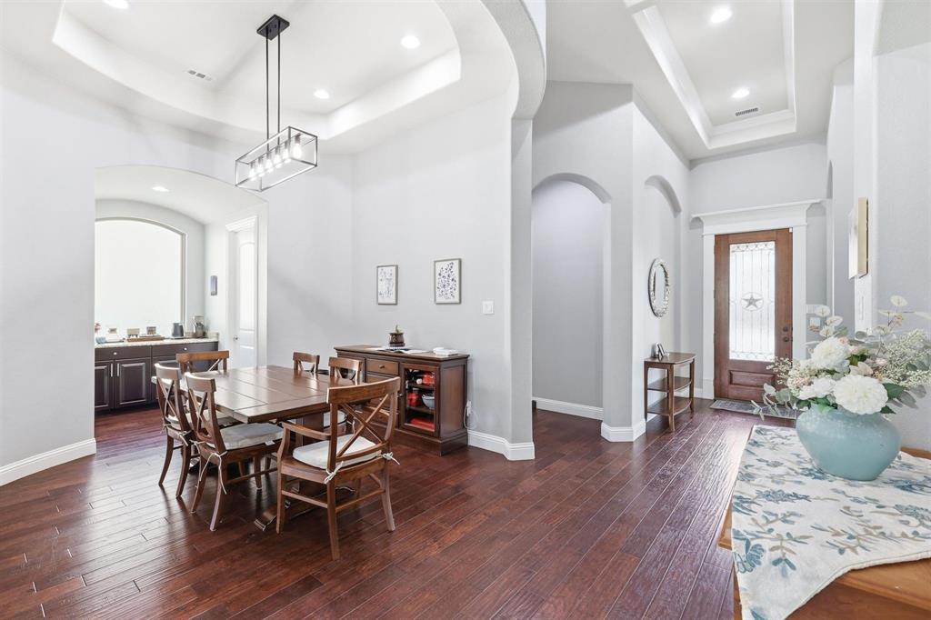 117 Birdcall Lane Argyle, TX 76226 - Photo 14 of 40 Dining area with a raised ceiling, arched walkways, recessed lighting, and dark wood-style floors