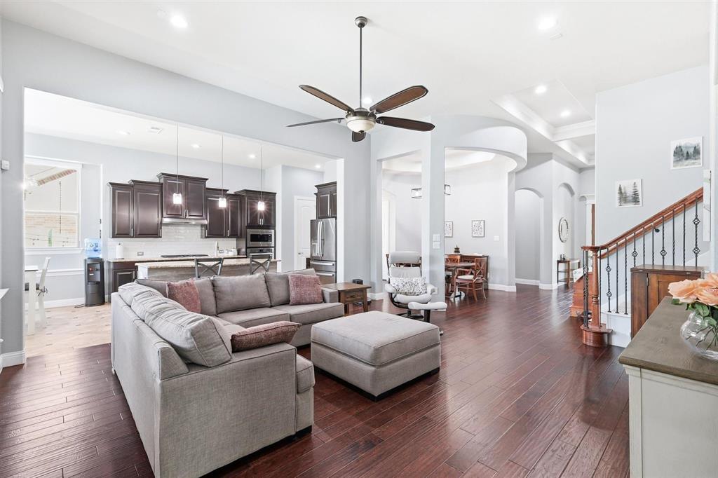 117 Birdcall Lane Argyle, TX 76226 - Photo 18 of 40 Living room featuring ceiling fan, dark wood finished floors, stairs, recessed lighting, and arched walkways