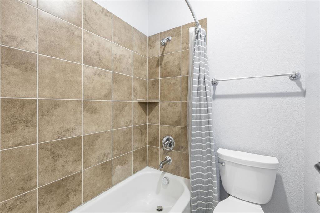 117 Birdcall Lane Argyle, TX 76226 - Photo 10 of 40 Bathroom with shower / tub combo with curtain and a textured wall