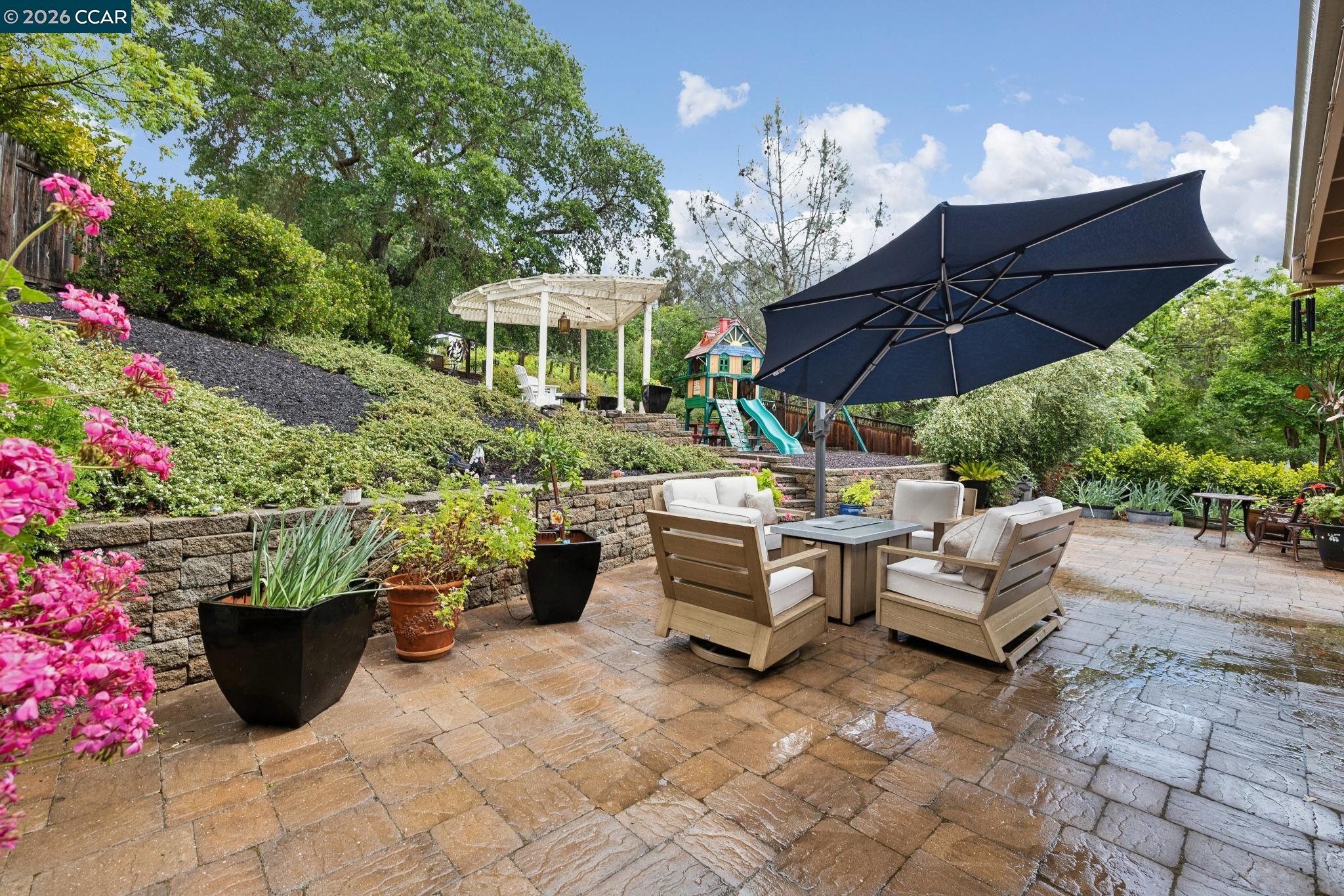 1980 Meadow Road Walnut Creek, CA 94595 - Photo 44 of 59 a view of a patio with couches table and chairs under an umbrella