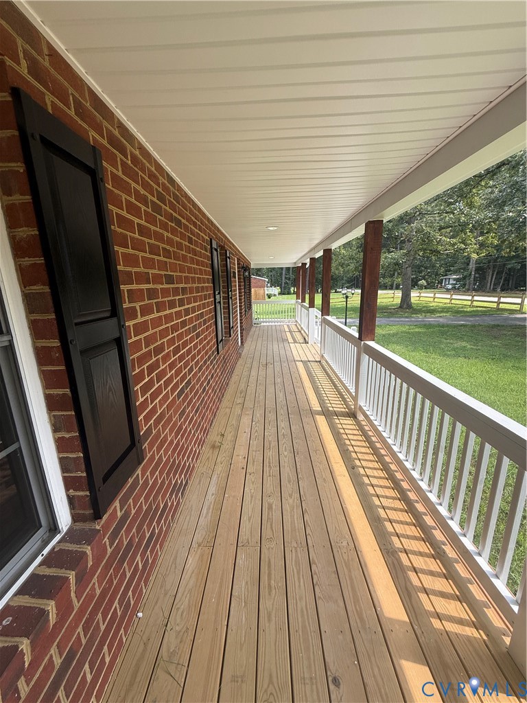 Expansive covered porch featuring a wooden deck, r