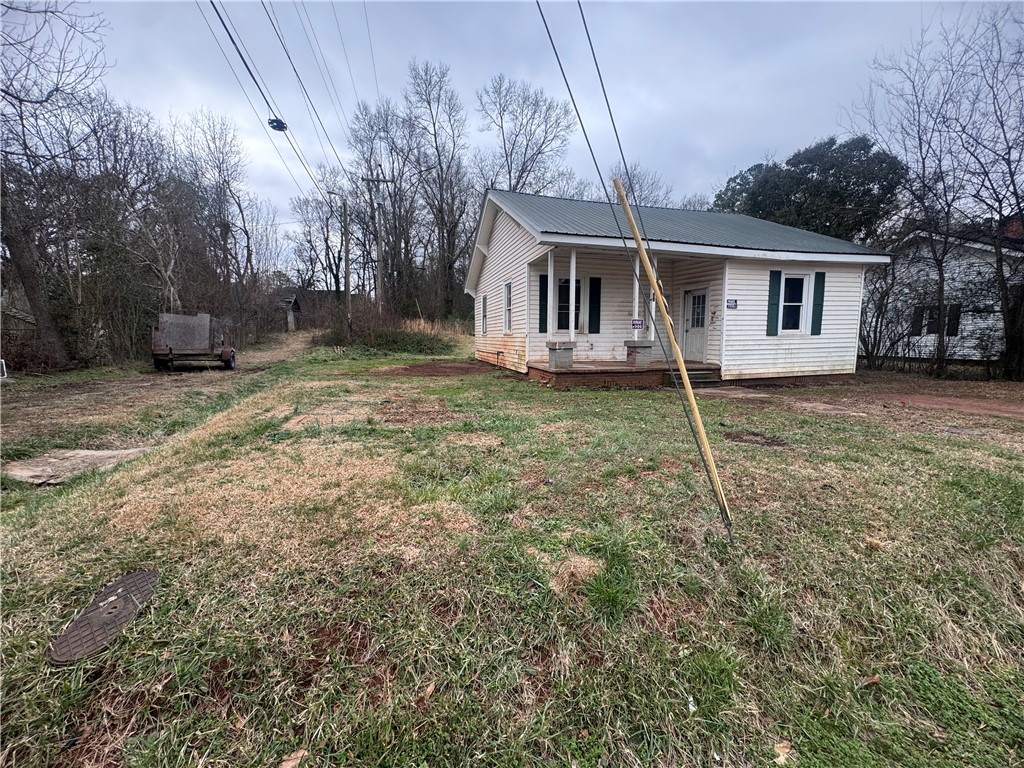 32 Ames Street Seneca, SC 29678 - Photo 14 of 14 This cozy home features a welcoming porch, a verdant yard, and mature trees.