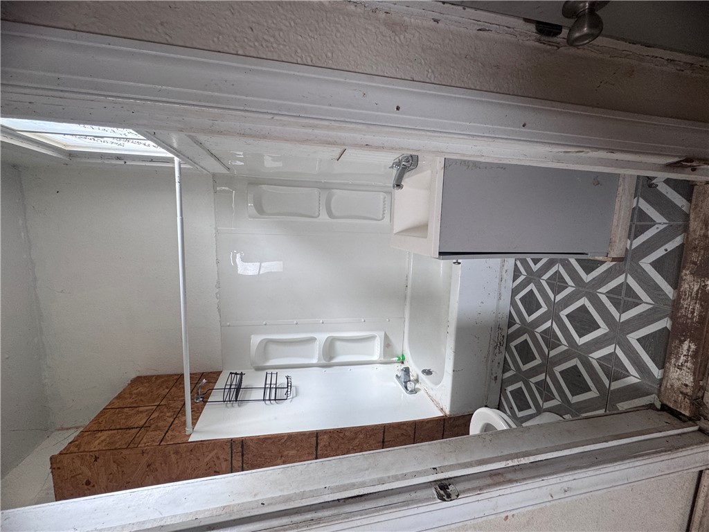 32 Ames Street Seneca, SC 29678 - Photo 7 of 14 This bathroom features a shower, sink, and toilet, complete with patterned tile flooring.