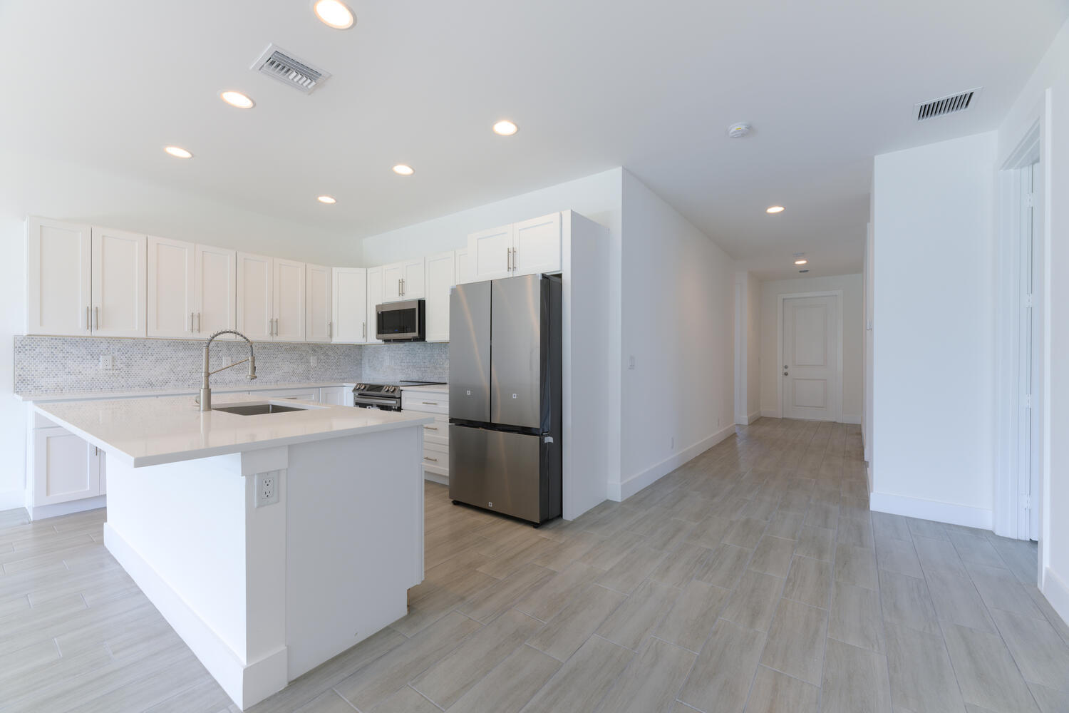 18058 Limestone Creek Road Jupiter, FL 33458 - Photo 24 of 30 a kitchen with a sink a refrigerator a microwave and cabinets