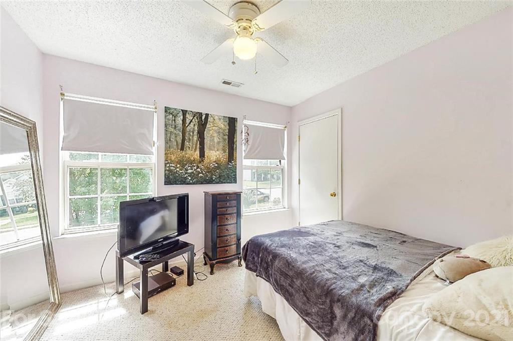 3053 Rockingham Court Southwest Concord, NC 28025 - Photo 14 of 28 a bedroom with a bed a chair and large windows