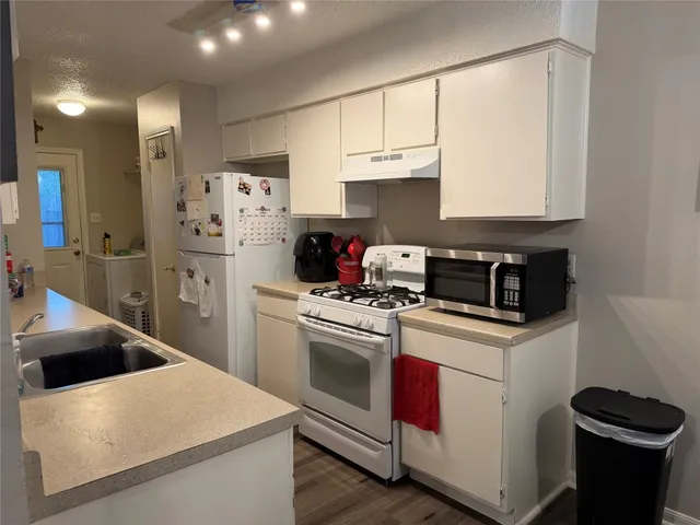 a kitchen with appliances cabinets and a sink