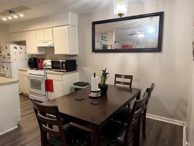 a kitchen with a dining table chairs and refrigerator