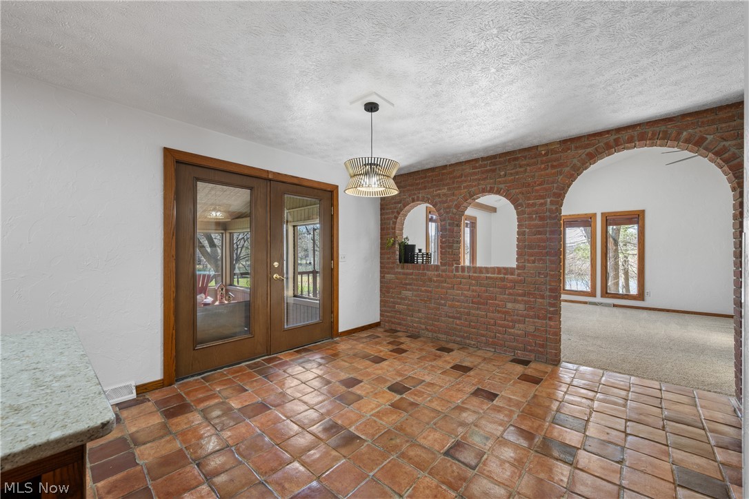490 Johnson Road Kent, OH 44240 - Photo 10 of 49 French doors lead from kitchen dining area to screened in porch. Unique brick archway opens into living room.