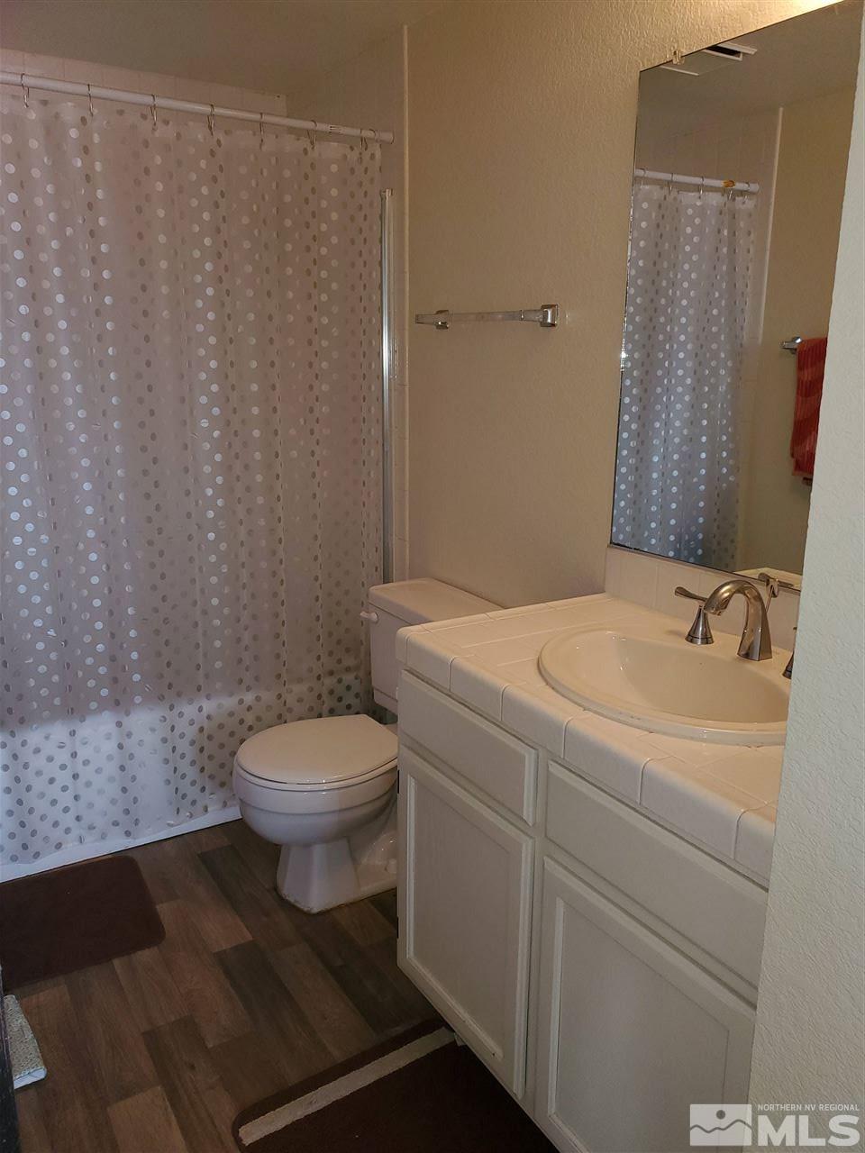 6940 Flower Street Reno, NV 89506 - Photo 13 of 20 a white toilet sitting next to a bathroom sink