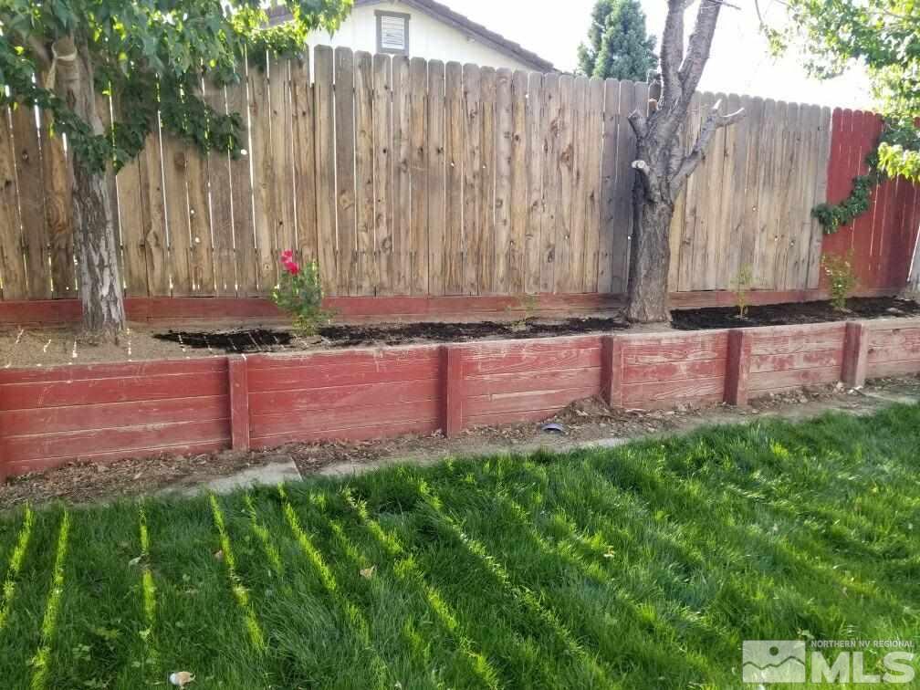 6940 Flower Street Reno, NV 89506 - Photo 19 of 20 a view of a back yard with potted plants and wooden fence