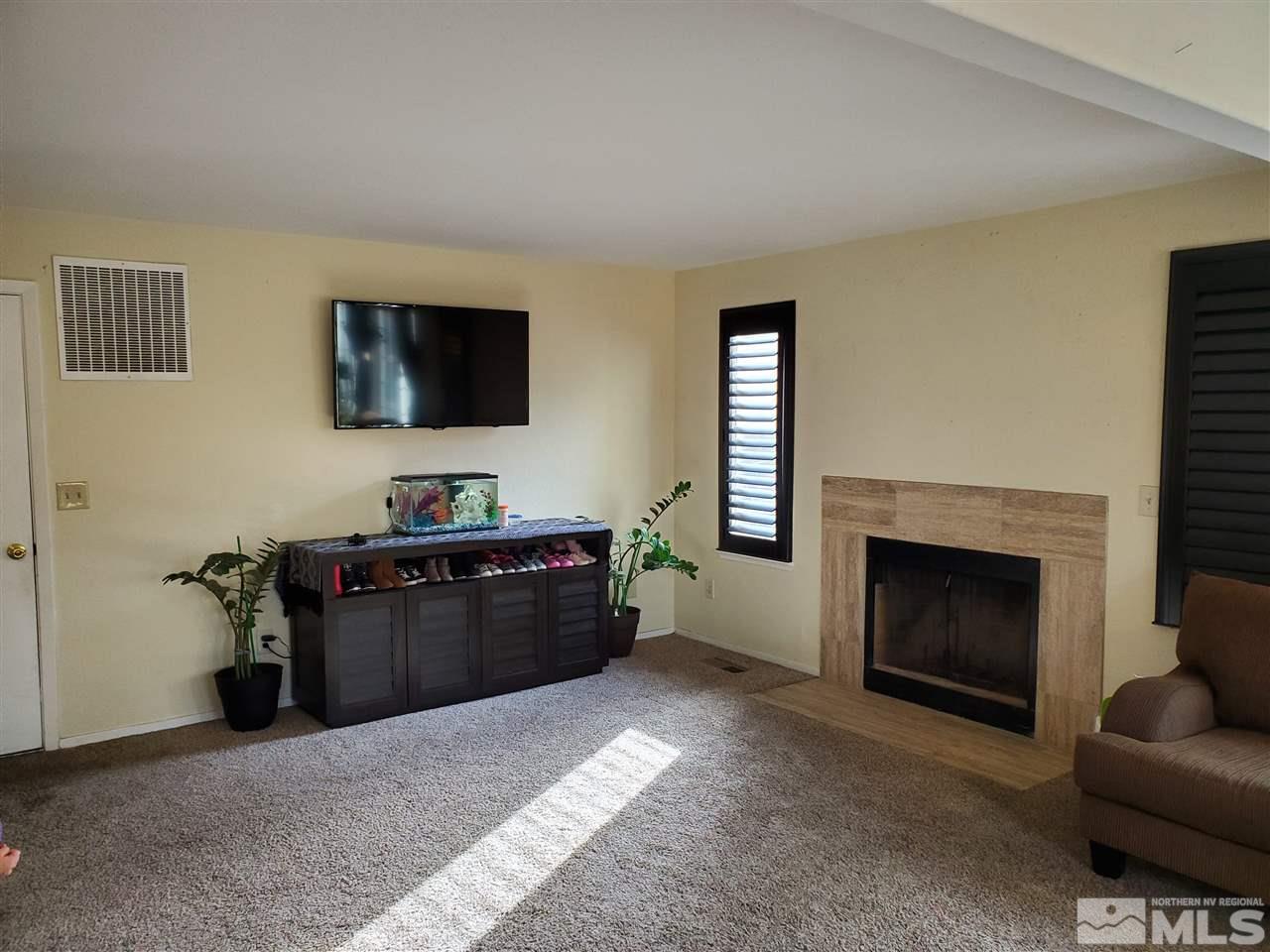 6940 Flower Street Reno, NV 89506 - Photo 3 of 20 a living room with furniture a flat screen tv and a fireplace