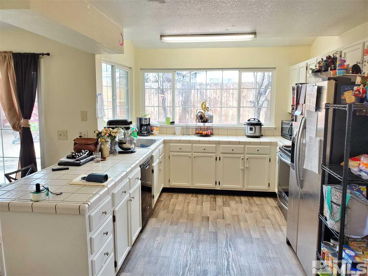 6940 Flower Street Reno, NV 89506 - Photo 6 of 20 a kitchen that has a lot of cabinets a sink and a wooden floor