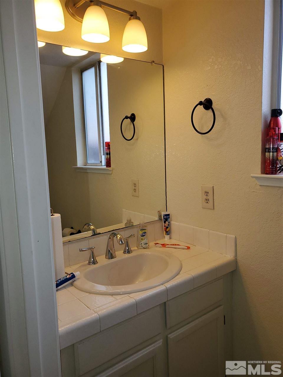 6940 Flower Street Reno, NV 89506 - Photo 8 of 20 a bathroom with a sink and a mirror