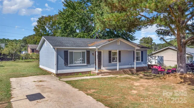 a front view of house with yard and trees in the background