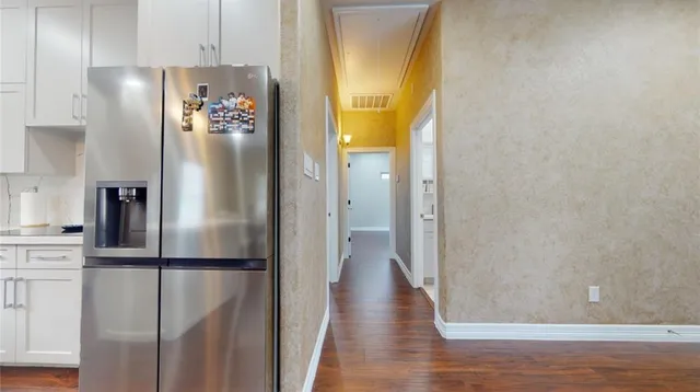 a view of a kitchen with wooden floor and a refrigerator
