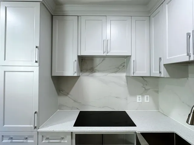 a white kitchen with a stove and a refrigerator