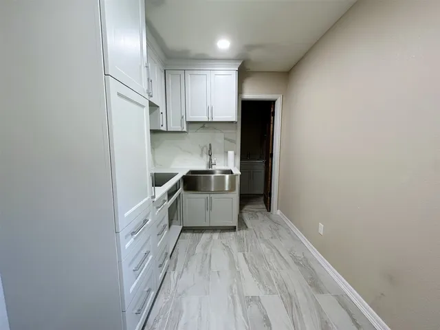 a kitchen with granite countertop a sink and wooden floor