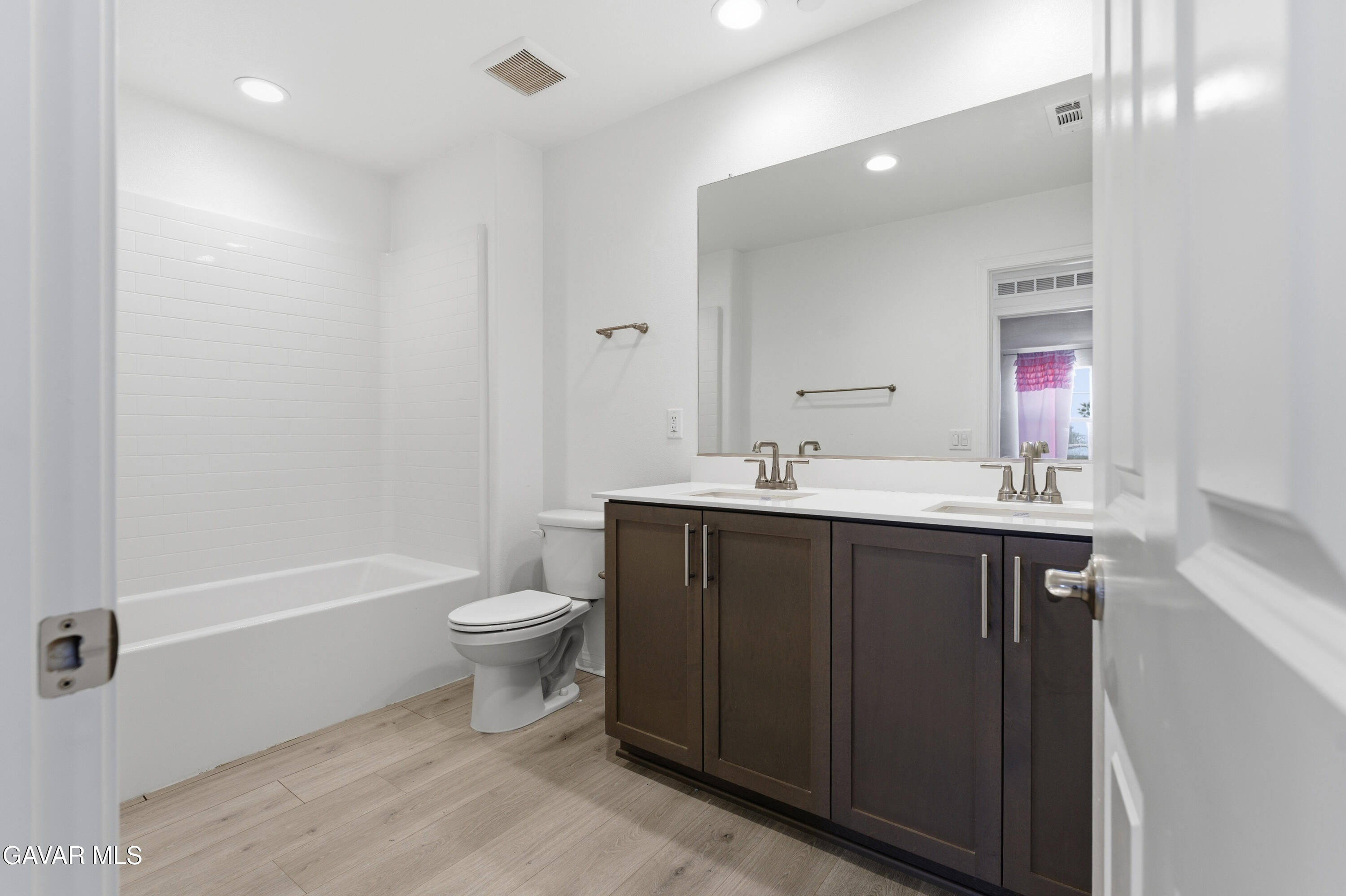 43869 Hampton Street Lancaster, CA 93536 - Photo 11 of 20 a bathroom with a sink a toilet a mirror and shower