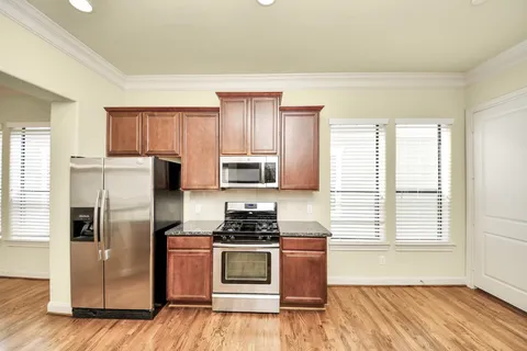 a kitchen with a refrigerator and a stove top oven