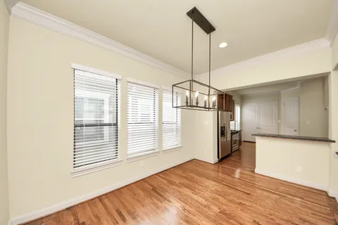 a kitchen with stainless steel appliances granite countertop a refrigerator a oven and a wooden floors