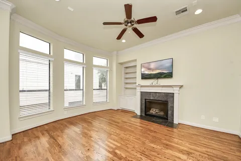 a view of empty room with a fireplace and wooden floor